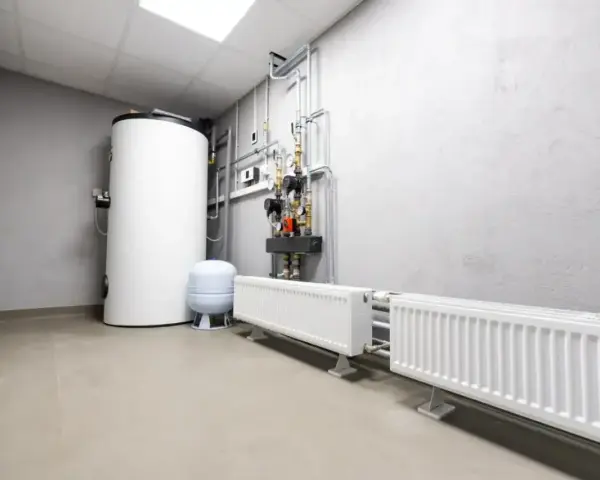 Kotłownia z bojlerem, pompami i grzejnikami. Widać tu instalację grzewczą, gdzie separator co zapewnia prawidłowy obieg wody.