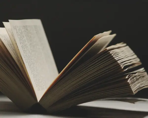 Un libro abierto revela páginas llenas de texto, evocando la sabiduría y las **frases en francés de la vida** que inspiran.