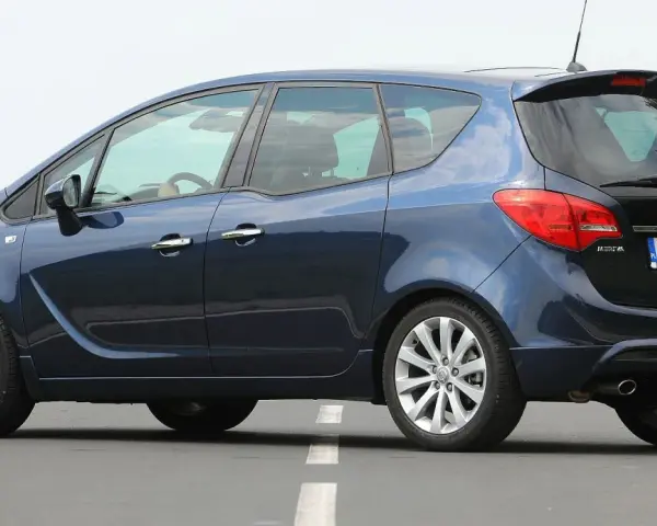 Ciemnoniebieski Opel Meriva B z polskimi tablicami WE 3428V na drodze.
