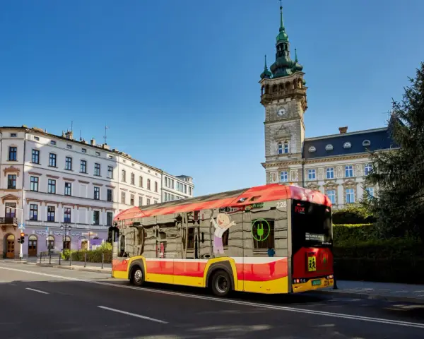 Autobus MPK Bielsko Biała z wizerunkiem uśmiechniętej postaci i zieloną wtyczką. Sprawdź rozkład jazdy MPK Bielsko Biała!
