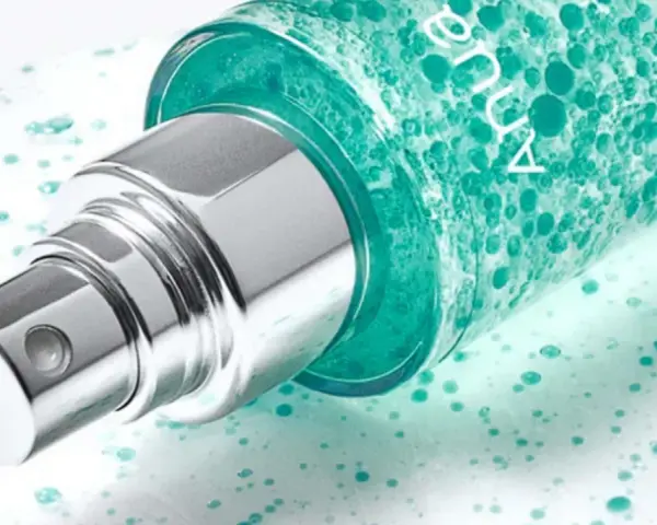 Szklana buteleczka z zielonym serum, widoczny srebrny atomizer. Na opakowaniu widnieje napis "anua niacinamide 10 + txa 4".