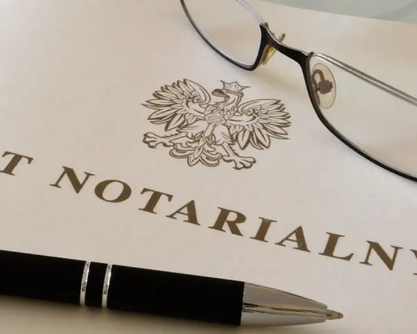Akt notarialny z orłem, długopis i okulary.