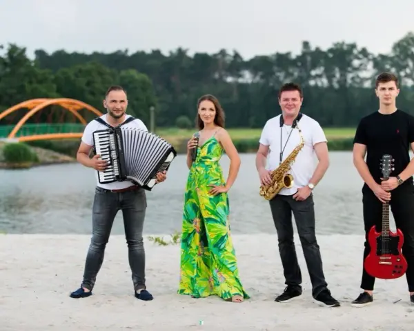 Teraz my - zespół skład: akordeonista, wokalistka, saksofonista i gitarzysta pozują na plaży.