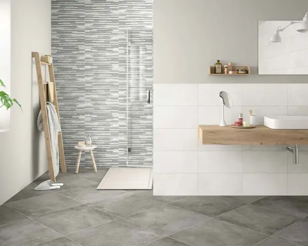 Baño moderno con ducha de azulejos grises y blancos. Aprende como limpiar azulejos baño para mantenerlo impecable.