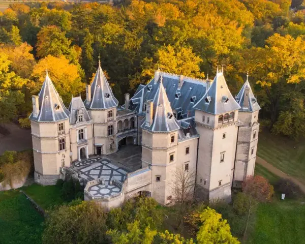 Piękny zamek w otoczeniu jesiennych drzew. Wspaniały przykład zamków w Polsce, zachwyca architekturą i kolorami.