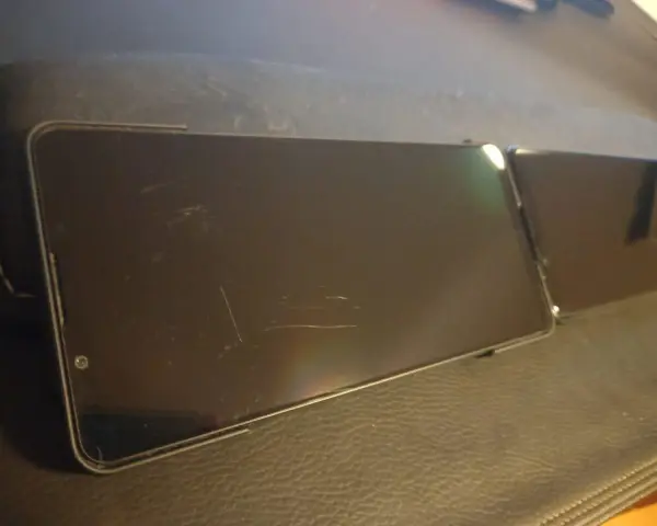 Dwa smartfony leżą obok siebie. Ekran jednego z nich, wykonany z Gorilla Glass Victus 2, nosi ślady zarysowań.