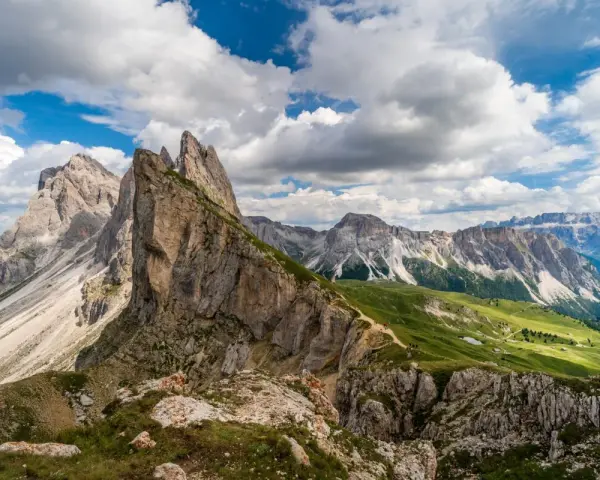 Majestatyczne szczyty Dolomitów w Val Gardena, zielone zbocza i malownicza ścieżka dla turystów.