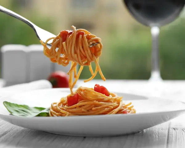 Widok na talerz z makaronem spaghetti i pomidorkami, idealny do rozważań, jakie wino do carbonary.