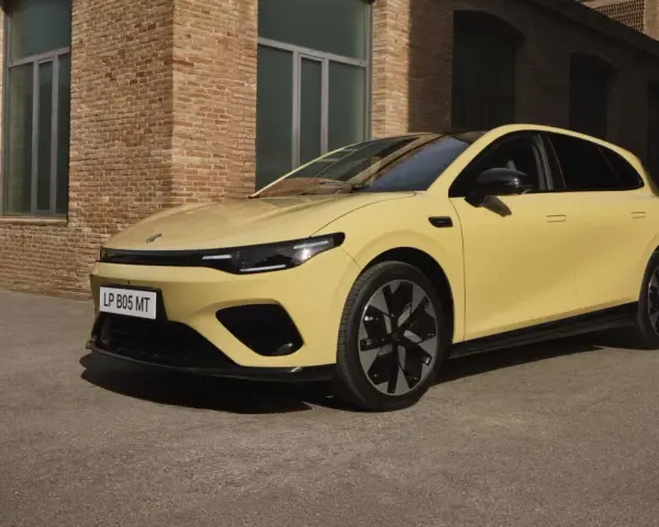 Żółty Leapmotor B05 z czarnym dachem i felgami, zaparkowany przed ceglanym budynkiem.