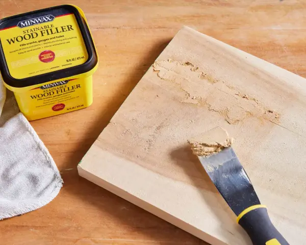 Learn how to use wood filler to repair cracks and gouges on wood. A Minwax container and putty knife are shown.