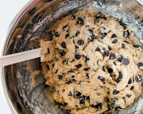 Impasto per biscotti fatti in casa con gocce di cioccolato, pronto per essere infornato.