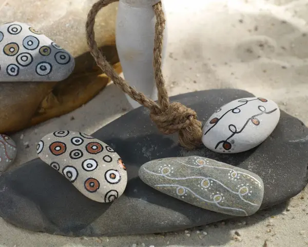 Piedras decoradas con rotuladores, creando patrones circulares y líneas onduladas. Un detalle artesanal para coleccionar.