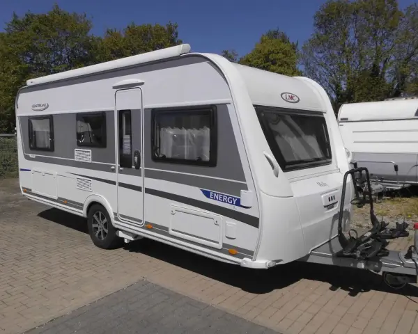 Nowy lmc caravan "Energy" gotowy na wakacje. Biało-szary, z bagażnikiem na rowery.