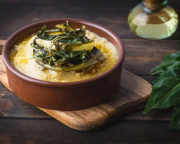 Polenta cremosa con cicoria in padella, un piatto rustico e saporito.
