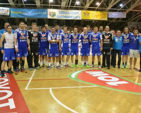 Drużyna piłkarzy ręcznych PICK Szeged w niebieskich strojach pozuje do zdjęcia po meczu.