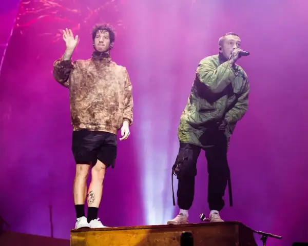 Tyler Joseph i Josh Dun z twenty one pilots na koncercie. Jeden wita publiczność, drugi śpiewa.