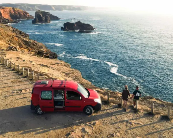 Para z kamperem na klifie w Portugalii, podziwiająca ocean. Niezapomniana podróż kamperem po Portugalii.