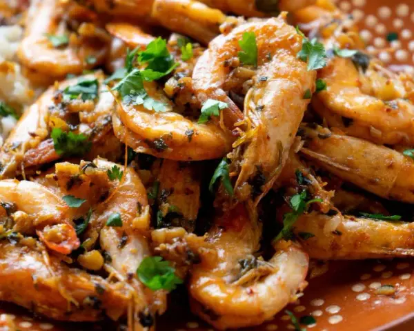 Langostinos en salsa, jugosos y llenos de sabor, servidos con arroz blanco. Un plato que invita a disfrutar.