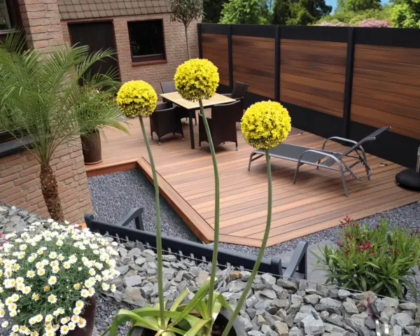 Giardino moderno senza erba: deck in legno, ghiaia, piante in vaso e fiori bianchi. Esempi idee giardino senza erba.