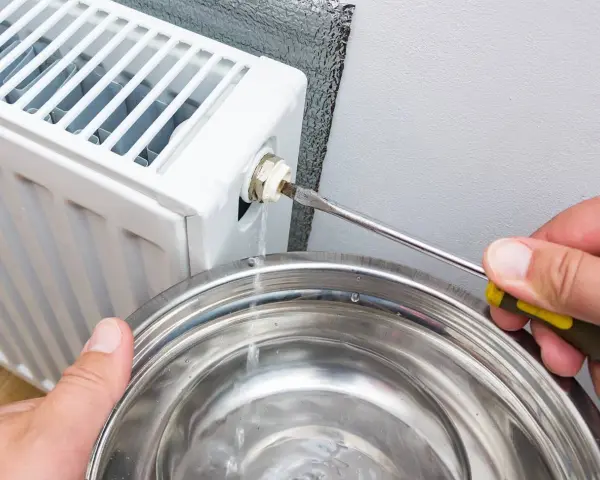 Lufta elementet för att få bort luft. Vatten rinner ner i en skål när en skruvmejsel används för att öppna ventilen.