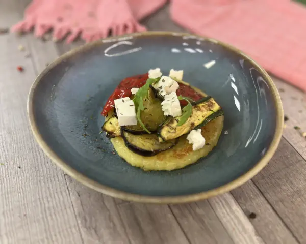 Gegrilltes Gemüse mit veganem Feta auf einem Kartoffelboden – ein köstliches Gericht für veganes Grillen.