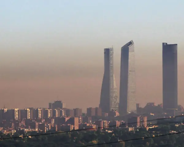 Edificios altos se alzan en una bruma densa, sugiriendo una ciudad mas contaminada del mundo.