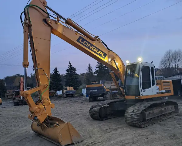 Żółta koparka gąsienicowa Liebherr z napisem LONGI.PL gotowa do pracy. Dostępna do wynajęcia.