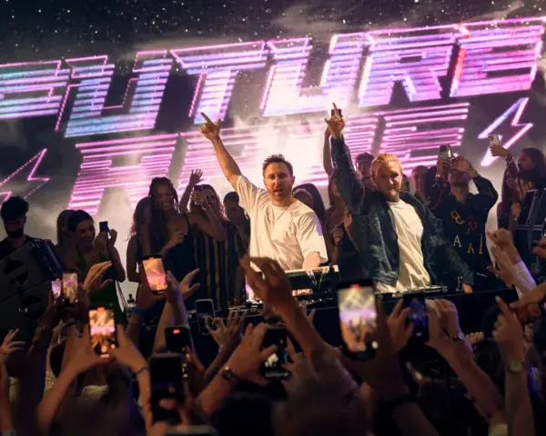 David Guetta und ein anderer DJ performen vor jubelnder Menge mit "FUTURE RAVE" Schriftzug.