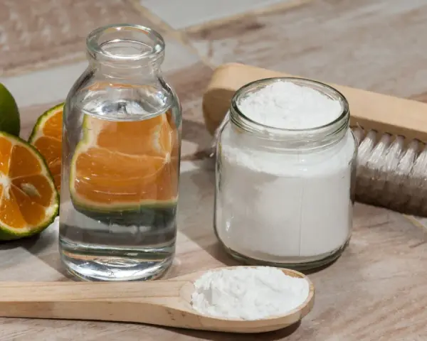 Ingredientes para blanquear ropa blanca con bicarbonato: naranjas, agua, bicarbonato y cepillo.