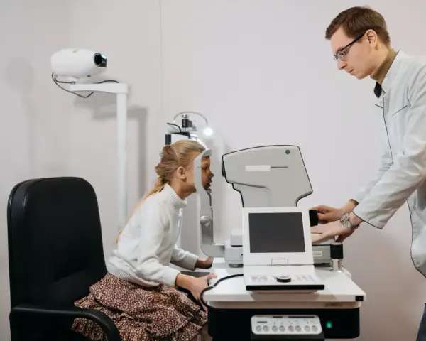Okulista bada wzrok dziewczynki. Czy do okulisty potrzebne jest skierowanie? Zależy od placówki.