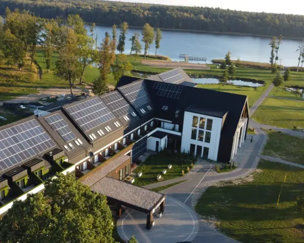 Nowoczesny hotel z panelami słonecznymi nad jeziorem, idealny na Mazury all inclusive.