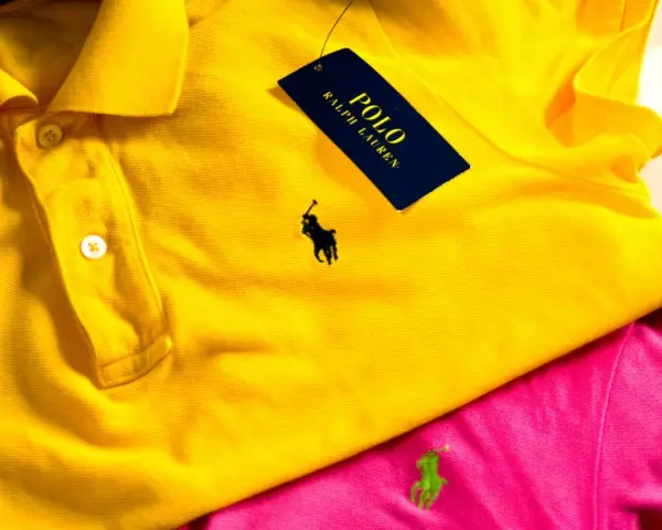Żółta koszulka polo z czarnym polo ralph lauren znaczek. Obok różowa koszulka z zielonym logo.