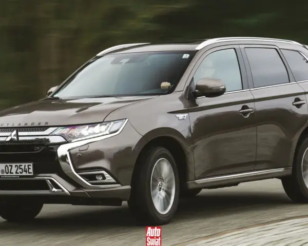 Brązowy Mitsubishi Outlander PHEV jedzie po drodze.