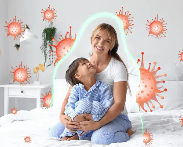 Mama tuli dziecko, które miało kaszel w nocy. Wokół nich wirusy, ale chroni je zielona bariera.