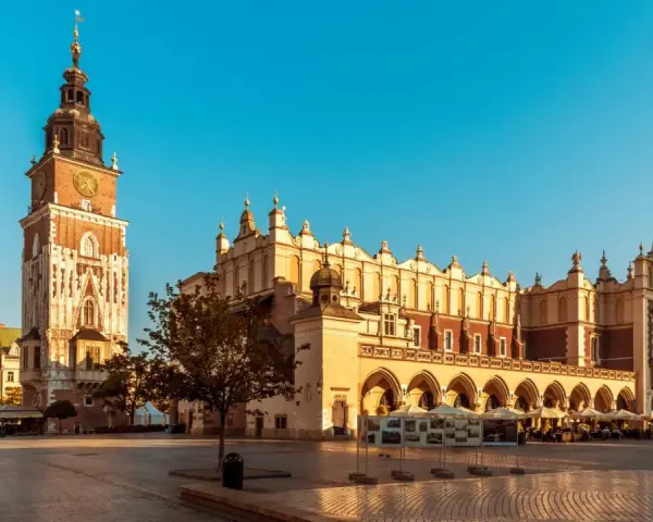 Rynek Główny w Krakowie z Sukiennicami i Wieżą Ratuszową w słoneczny dzień.