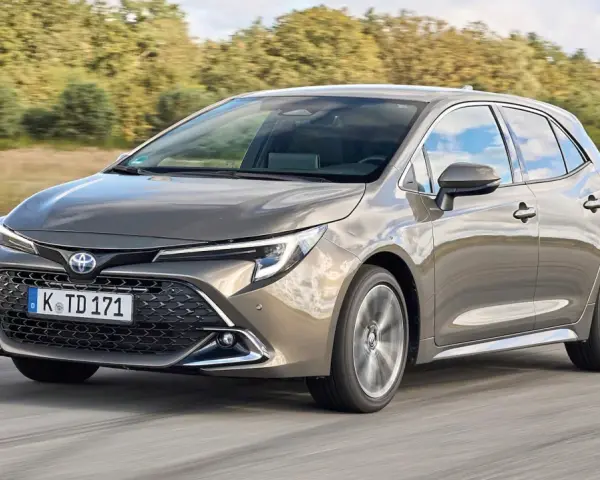 Grauer Toyota Corolla 2.0 Hybrid fährt auf Straße. Mögliche Probleme mit dem Hybridantrieb sind hier kein Thema.