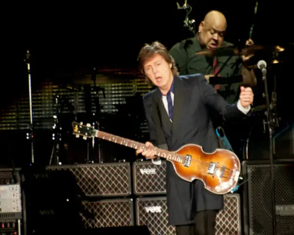 Paul McCartney na jednym ze swoich koncertów, grając na gitarze basowej. W tle perkusista.