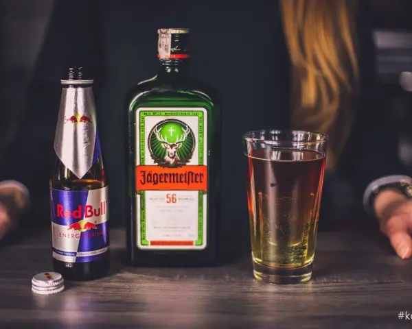 Butelka Jägermeistera, Red Bulla i szklanka z drinkiem. Czy jagermeister to whisky? Nie, to ziołowy likier.