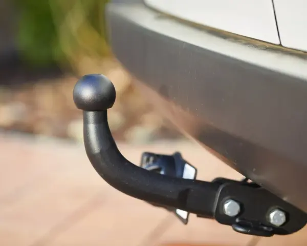 Gancio traino nero montato sul paraurti di un'auto, pronto per il traino secondo il codice della strada.