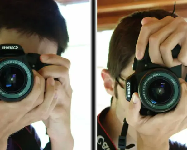 Un jeune homme apprend à photographier, tenant un appareil Canon pour capturer son reflet.