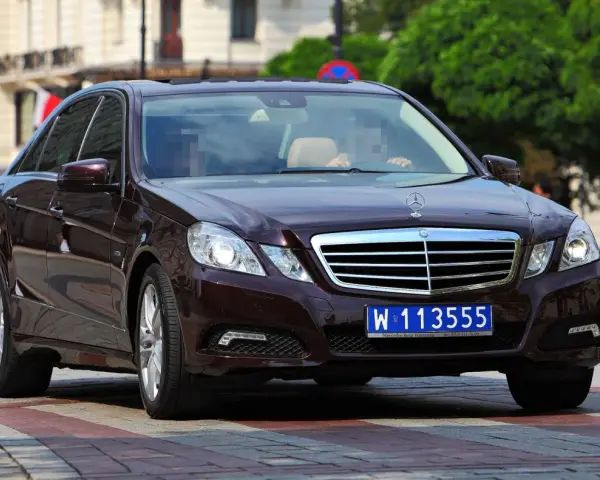 Ciemnobrązowy Mercedes z tablicami dyplomatycznymi W 113555, jadący po pasach.