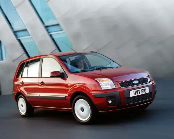 Czerwony Ford Fusion 1.4 benzyna w ruchu miejskim. Elegancka sylwetka i nowoczesny design.