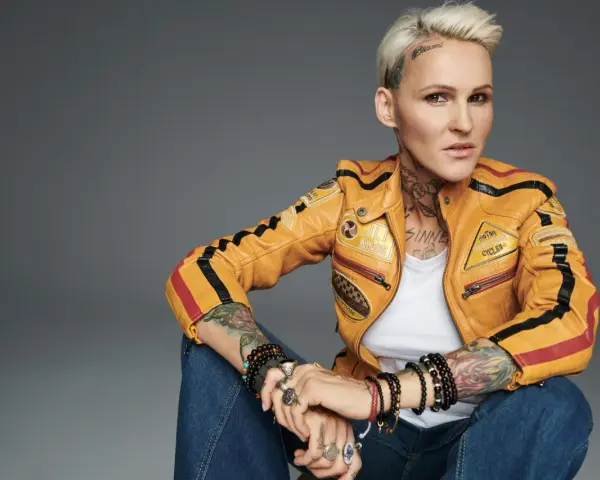 Agnieszka Chylińska w żółtej kurtce motocyklowej, z tatuażami i biżuterią. Jakby mówiła: "kiedyś do ciebie wrócę".