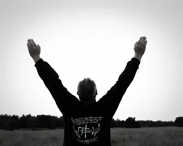 Mann mit erhobenen Armen im Freien, inspiriert von Psalm 92.