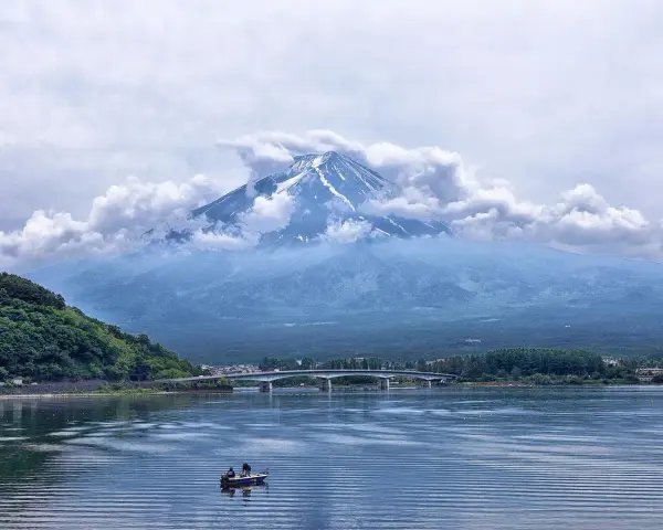 Majestatyczny Fudżi wyłania się z chmur nad jeziorem. Zastanawiasz się, ile się leci do Japonii, by zobaczyć ten widok?