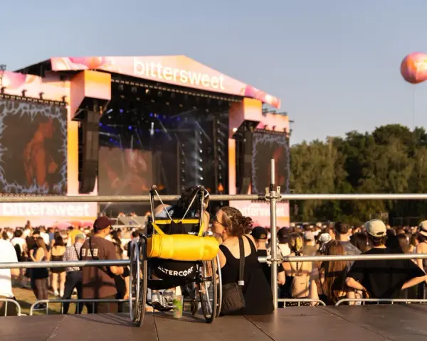Dwie osoby, jedna na wózku, dzielą intymną chwilę na festiwalu bittersweet.