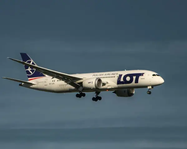 Samolot LOT Polish Airlines z bagażem podręcznym w locie, zbliżający się do lądowania.