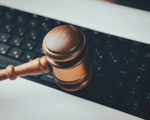 Marteau de juge sur un clavier d'ordinateur, symbolisant les revenus pris en compte pour pension alimentaire et la justice numérique.