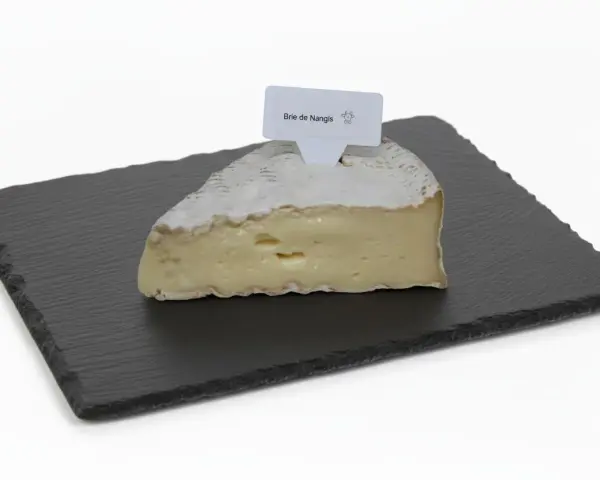 Une part de brie de Nangis, crémeux et à la croûte fleurie, repose sur une ardoise.
