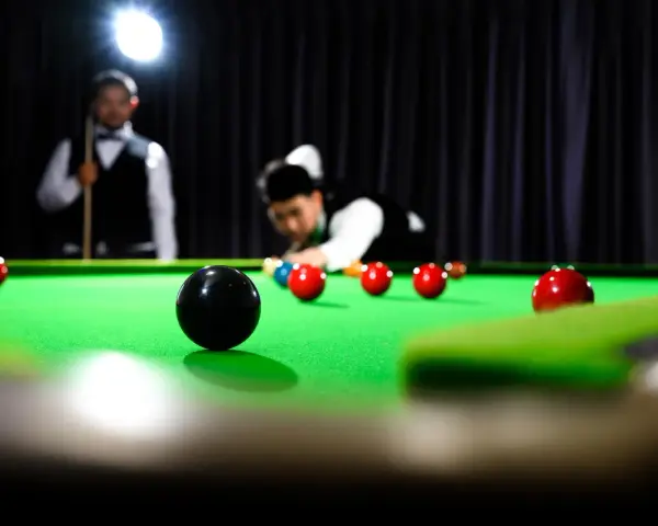 Gracze w skupieniu rozgrywają mecz snookera, zbliżając się do zwycięstwa w snooker mistrzostwa świata.